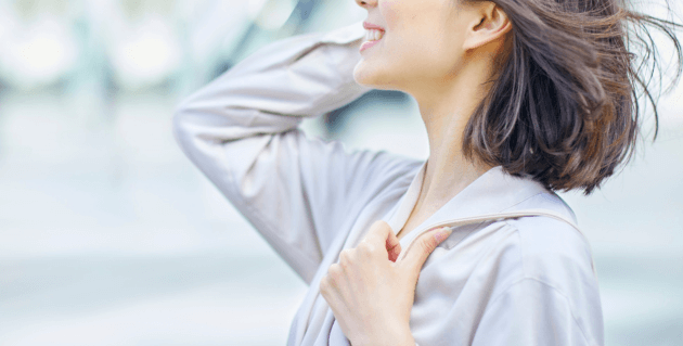 風に吹かれる笑顔の女性