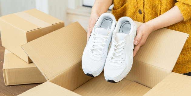箱からスニーカーを取り出す女性