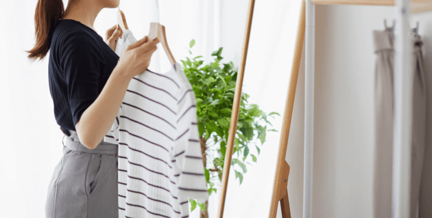 鏡の前で服を選ぶ女性